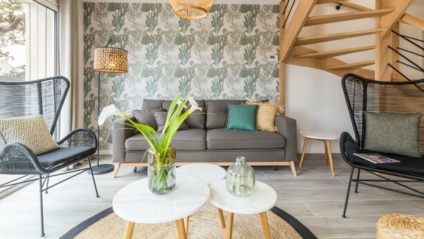 A modern living room with a grey sofa, black chairs, a white coffee table, and a staircase. - Independent house in Portbail, pets allowed, near the beach (Portbail)