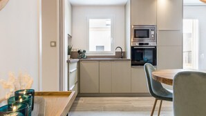 A modern kitchen with a built-in oven, microwave, and a window above the sink. - Independent house in Portbail, pets allowed, near the beach (Portbail)