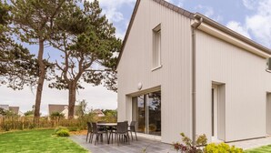 A modern two-story house with a patio, a dining area, and a large window. - Independent house in Portbail, pets allowed, near the beach (Portbail)
