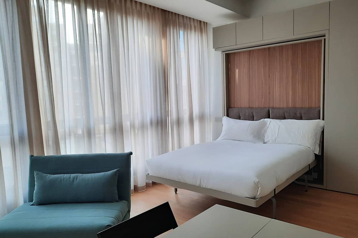 Une chambre d’hôtel moderne, équipée d’un lit, d’un canapé et d’un bureau.