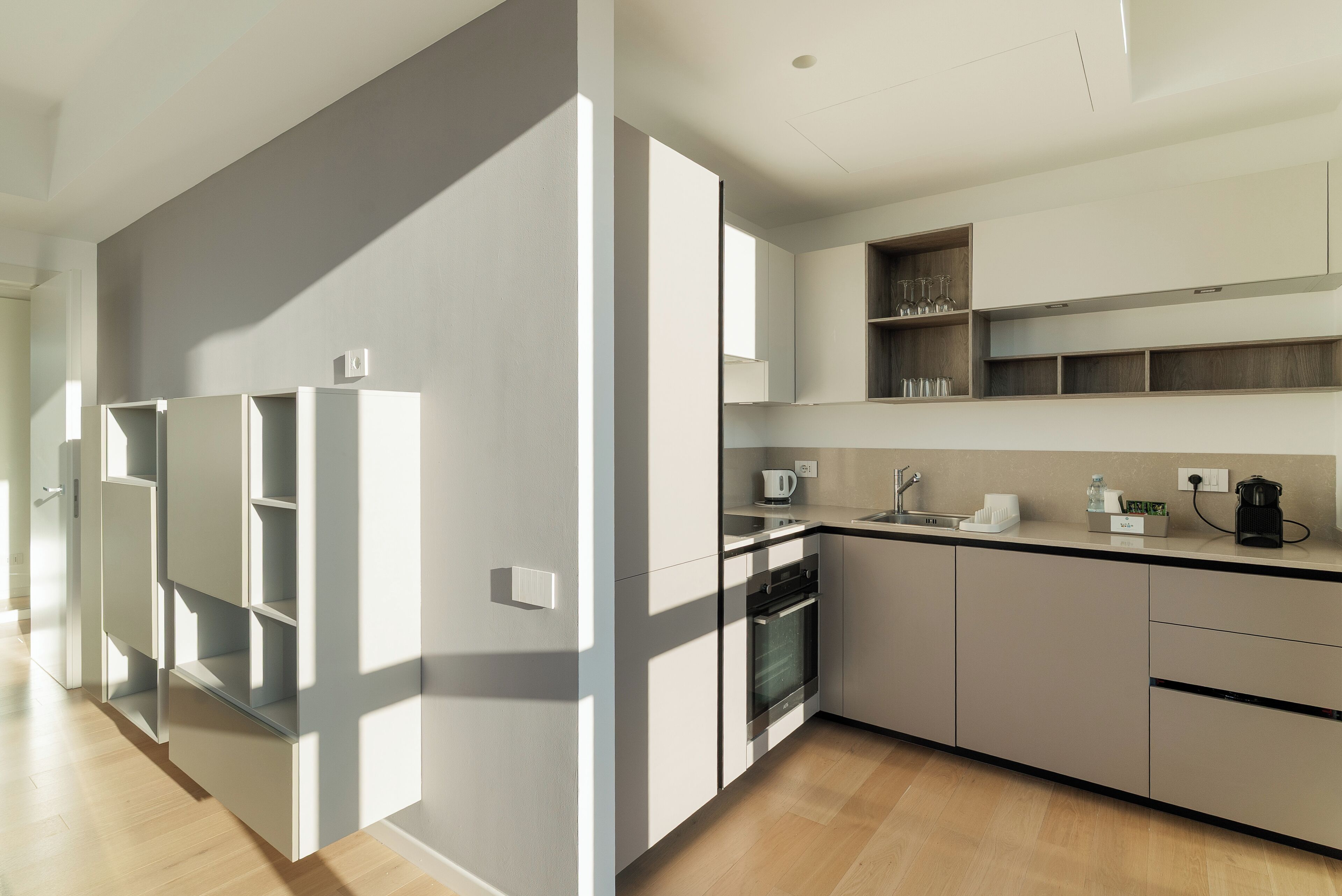 A modern kitchen with built-in appliances, a countertop with a coffee maker, and a sink.