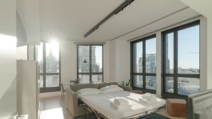 Un dormitorio moderno con una cama grande, un sofá y un escritorio.