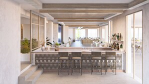 A spacious kitchen with a central island, bar seating, and a view of the dining area.