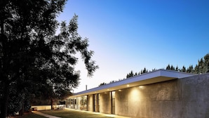 Un bâtiment moderne doté d’un toit plat, de grandes fenêtres et d’une façade en béton.