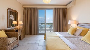Hotelkamer met een bed, een bureau, een stoel en uitzicht buiten via een schuifdeur.
