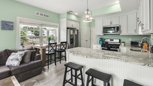 A modern kitchen with white cabinets, a granite countertop, and stainless steel appliances.
