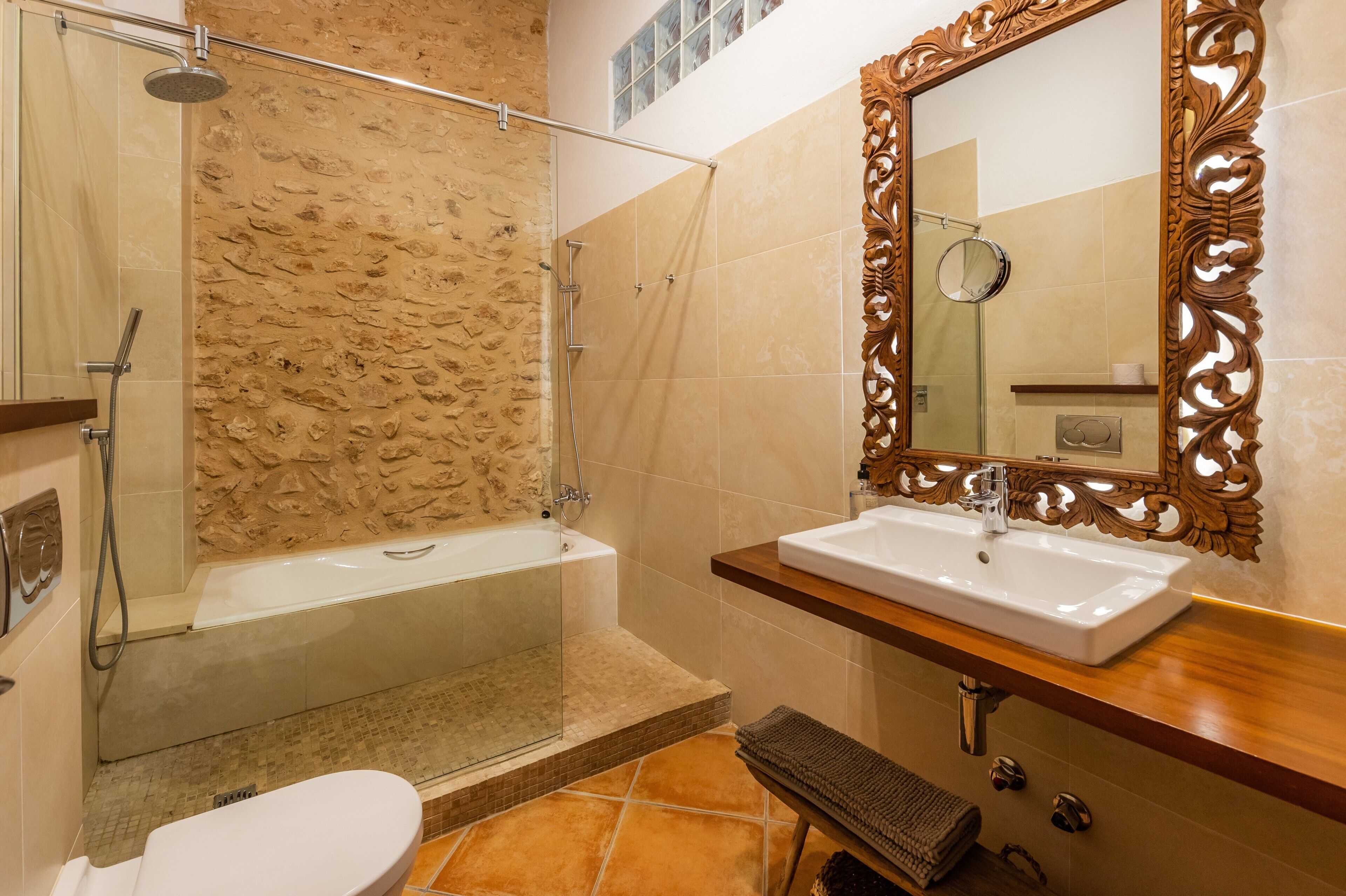 Un baño con bañera, ducha, lavabo y espejo.