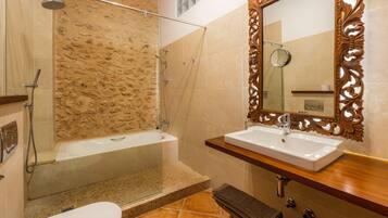 Un baño con bañera, ducha, lavabo y espejo.