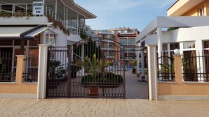 A gated entrance to a building with balconies and a sign indicating an internet cafe bar. - Sun City Hotel (Sunny Beach)