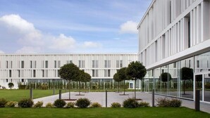 Un edificio moderno con tejado plano, ventanas amplias y fachada simétrica.