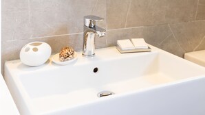 A bathroom with a large mirror, a white sink, and a towel rack. - Villa Leondari by Rodostamo Collection (Corfu)