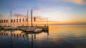 Ein Yachthafen mit mehreren Booten, die bei Sonnenuntergang an einem Steg vertäut sind.