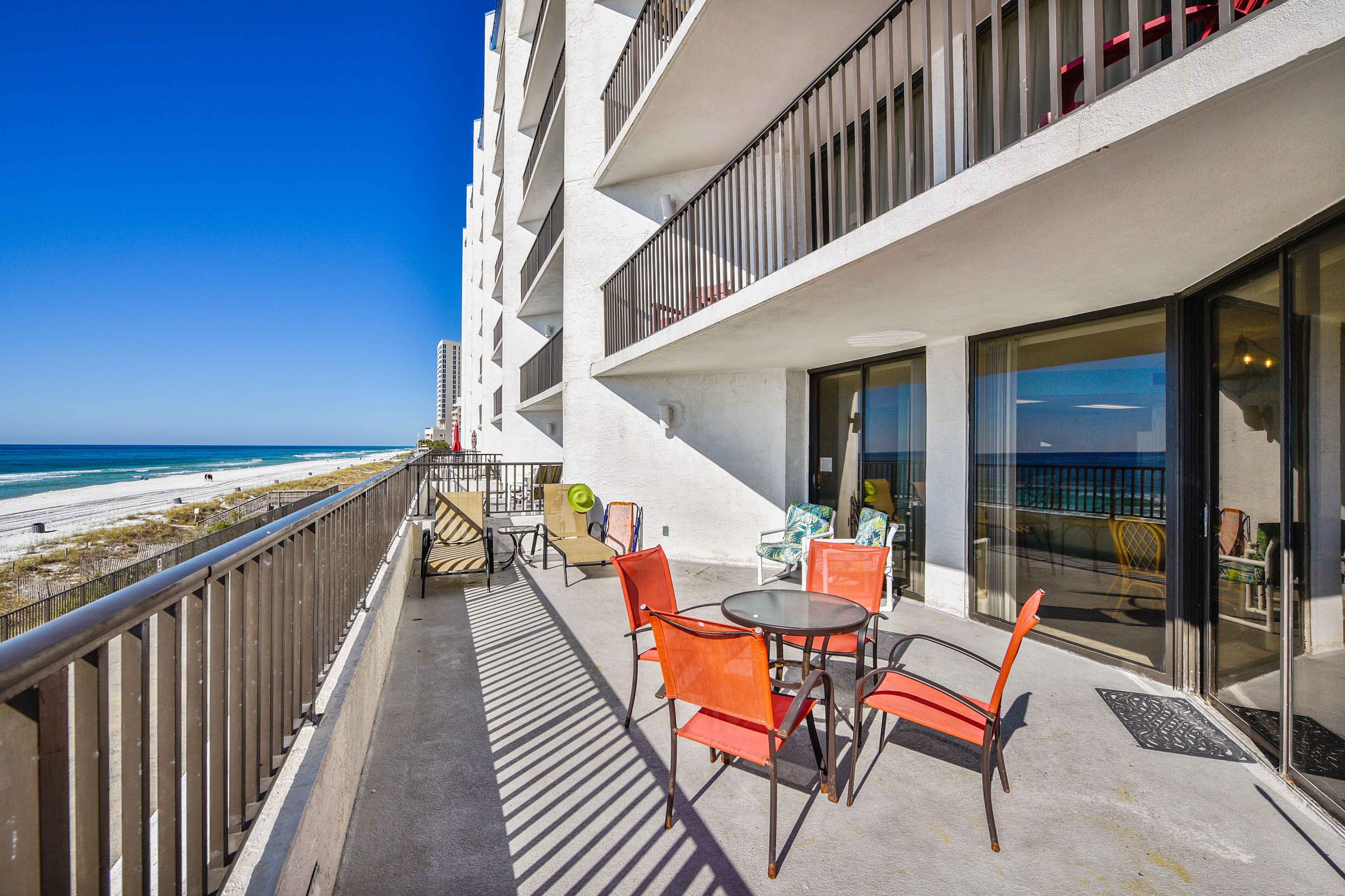 Un balcón con mobiliario exterior, con vista a una playa.
