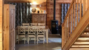 A wooden interior with a dining table and chairs, a chandelier, and a fireplace. - Le Familial 4* - SPA & SAUNA - 6 people (Rochesson)