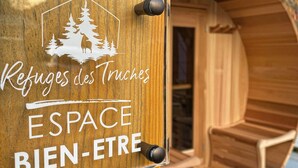 A wooden cabin with a sign reading "Refuges des Truches ESPACE BIEN-ETRE". - Le Familial 4* - SPA & SAUNA - 6 people (Rochesson)