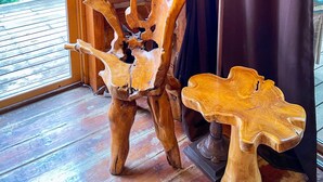 A wooden interior with a rustic ambiance, featuring a unique wooden sculpture and a table with a lamp. - Beautiful Log Cabin w/ Beachfront & Stunning Lake Views in Coeur d'Alene Idaho. (Harrison)