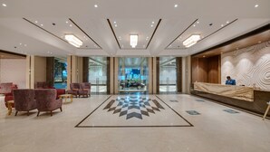 A spacious lobby with a checkered floor, seating area, and a reception desk. - The Fern Sardar Sarovar Resort, Series by Marriott (Garudeshwar)