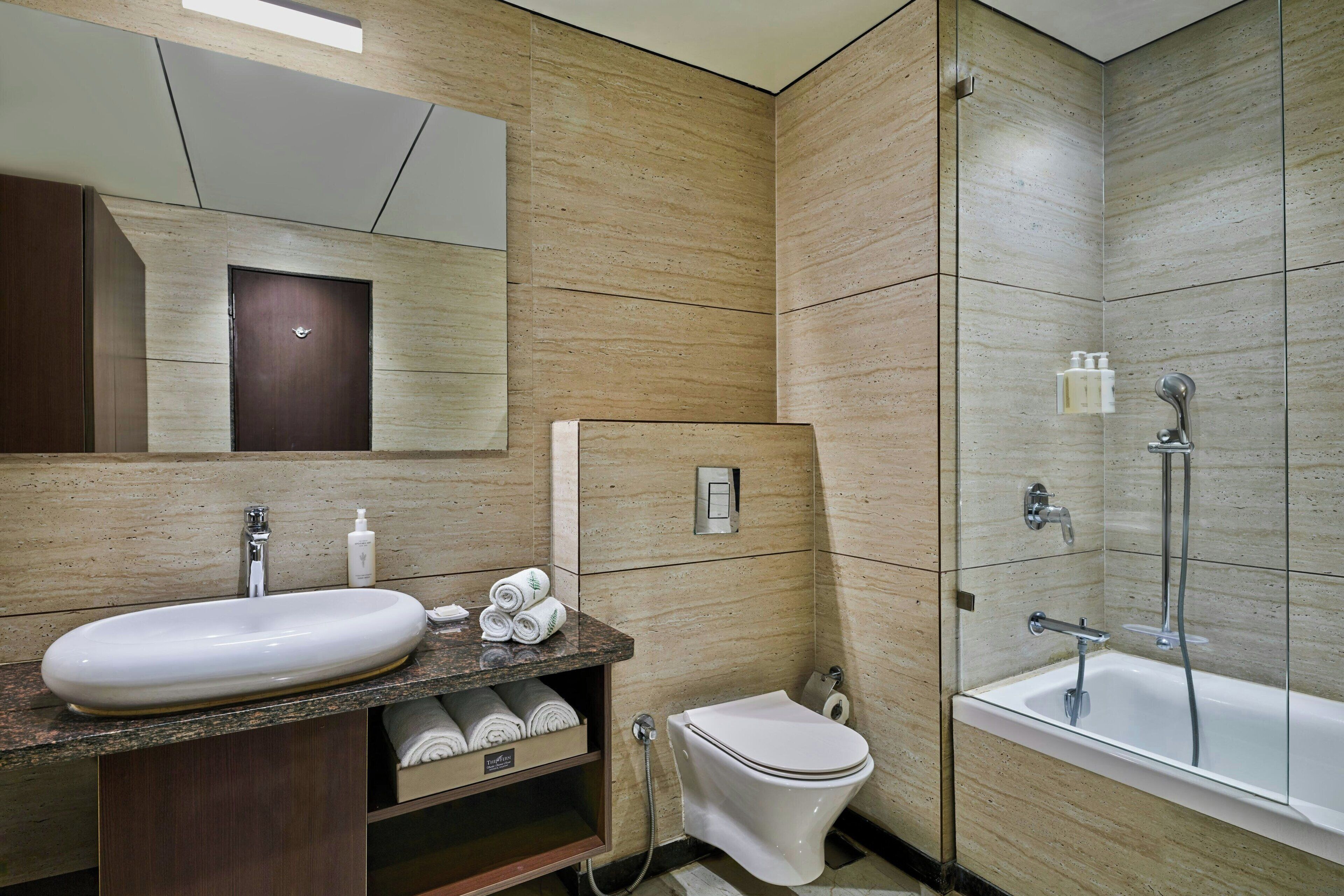 Ein modernes Badezimmer mit Marmorwaschtisch, Toilette und Badewanne.