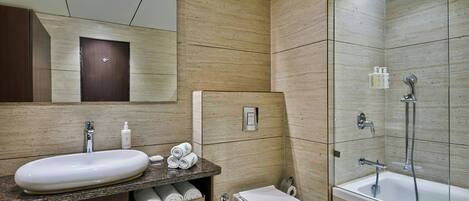 Ein modernes Badezimmer mit Marmorwaschtisch, Toilette und Badewanne.