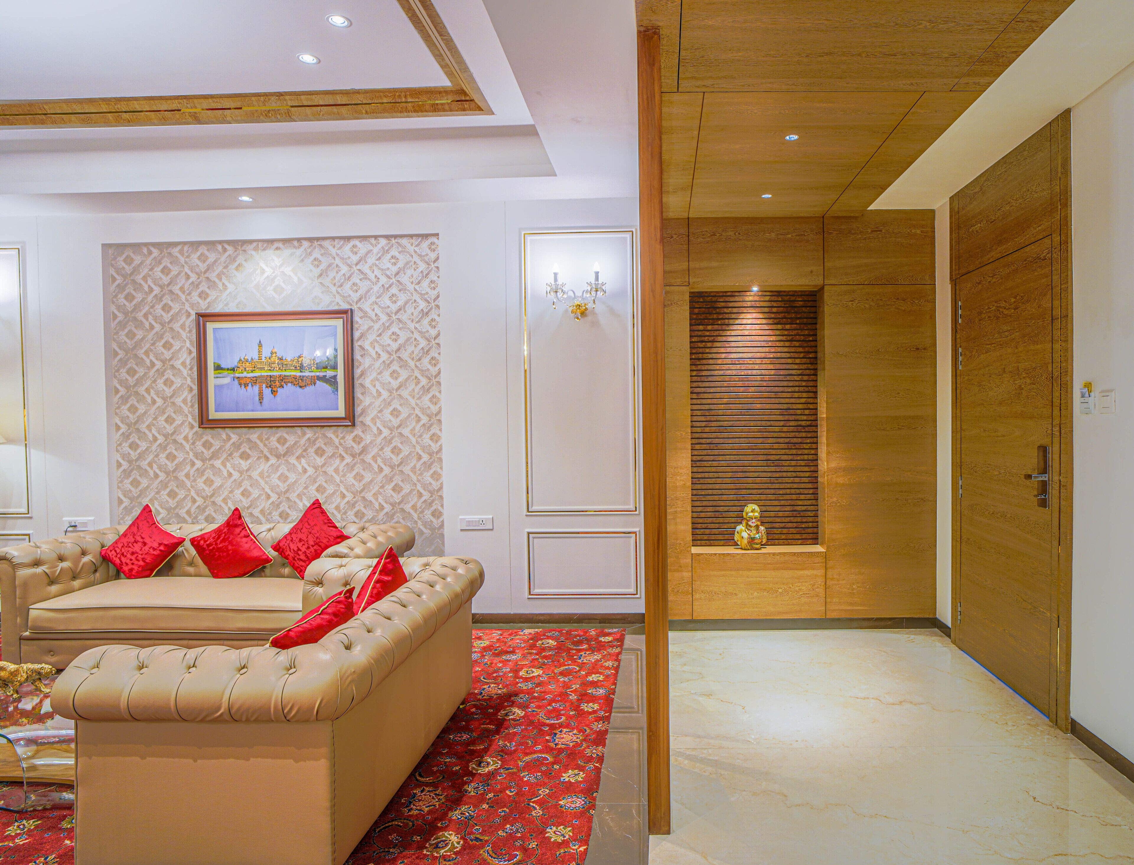 A well-lit living room with a beige sofa, red cushions, and a patterned wall.