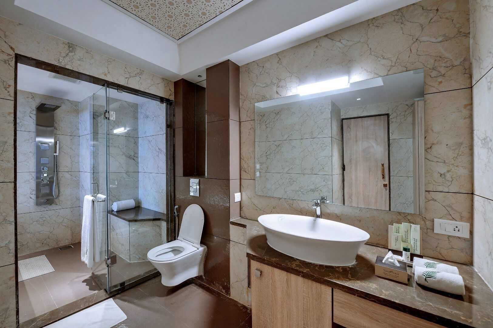 Ein modernes Badezimmer mit einer Duschkabine, einer Toilette und einer freistehenden Badewanne.