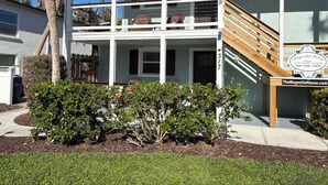 A two-story house with a wooden staircase, a balcony, and a sign indicating it is for rental. - SHORT WALK TO VILLAGE, BEACH - HEATED POOL - LUSH LANDSCAPING.
TWO UNITS. (Siesta Key)