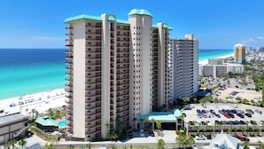 Ein Hochhaus-Hotel mit zahlreichen Balkonen mit Blick auf Strand und Meer.