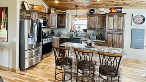 A modern kitchen with wooden cabinets, stainless steel appliances, and a granite countertop.