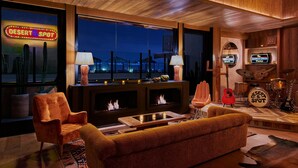 A cozy lounge area with a fireplace, comfortable seating, and a view of the night sky.