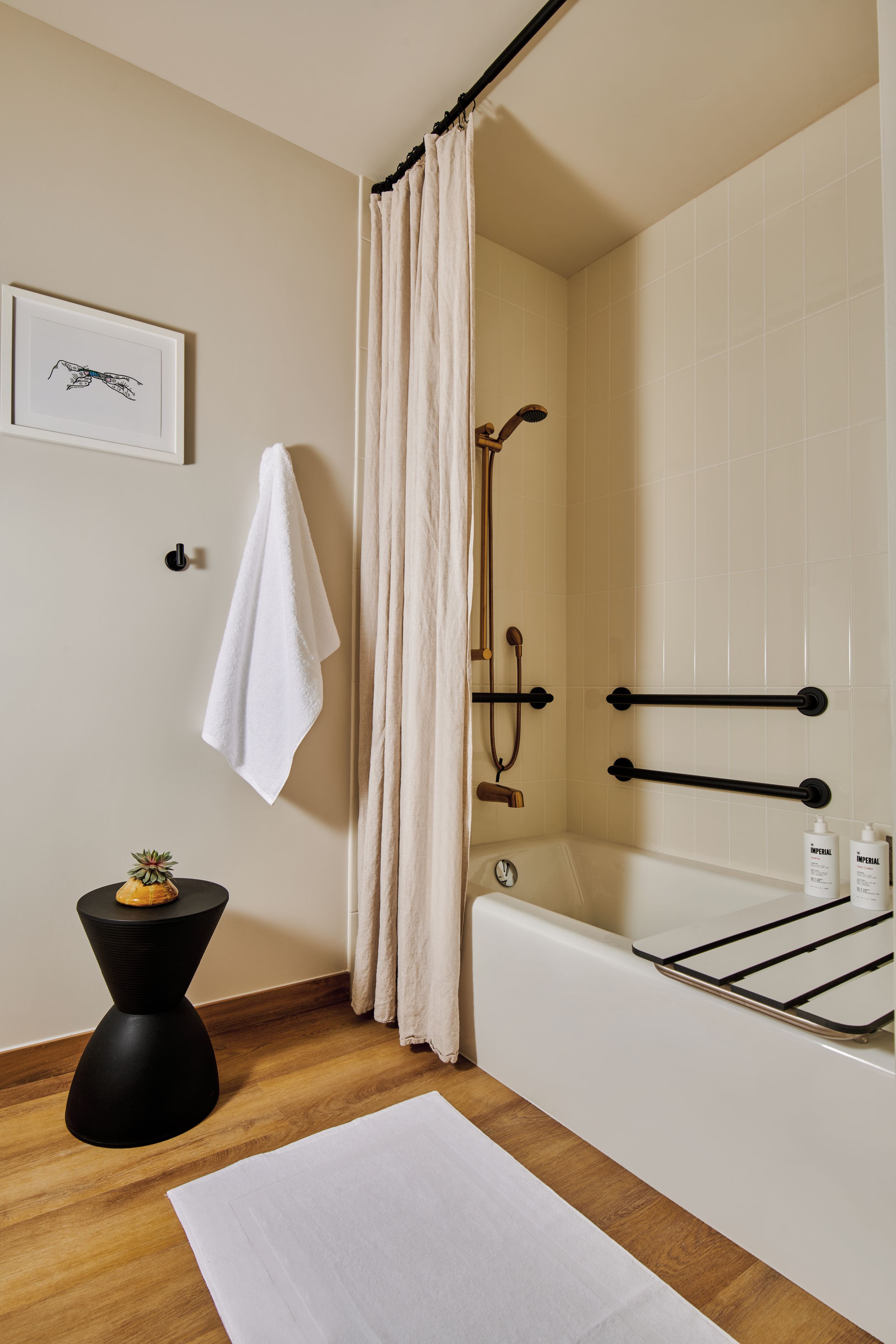 Une salle de bain moderne équipée d’une baignoire, d’une douche et d’un porte-serviettes.
