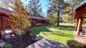 Eine Holzhütte mit überdachter Veranda und einem Rasen.