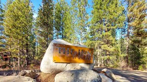 Ein großer Felsen mit einem Schild, auf dem "THE INN AT MAZAMA" steht.