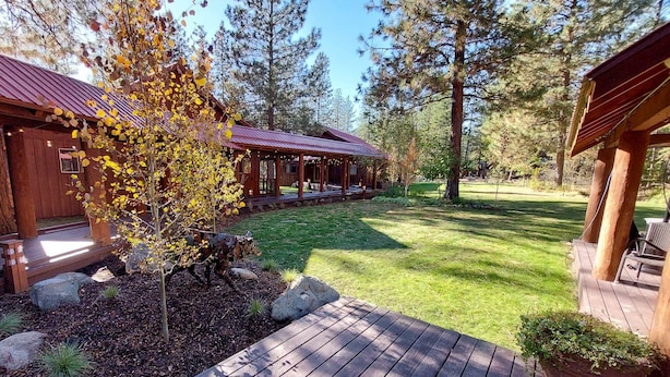 A wooden cabin with a covered porch and a grassy yard. - Cedar - pet-friendly room at The Inn At Mazama (Mazama)