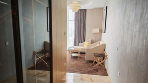 A modern hotel room with a marble floor, a sofa, a coffee table, and a dining area. - Jinjiang Metropolo Hotel (Shanghai Jing'an Pengpu Xincun Subway Station) (Shanghai)