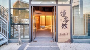 A hotel entrance with a glass door, a staircase to the left, and a sign with Chinese characters. - Jinjiang Metropolo Hotel (Shanghai Jing'an Pengpu Xincun Subway Station) (Shanghai)