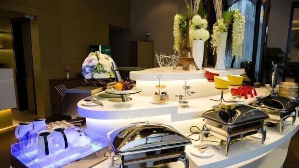 A buffet setup with various food stations and decorative elements. - Jinjiang Metropolo Hotel (Shanghai Jing'an Pengpu Xincun Subway Station) (Shanghai)