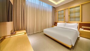 A hotel room with a large bed, a TV, a desk, and a window with curtains. - Jinjiang Metropolo Hotel (Shanghai Jing'an Pengpu Xincun Subway Station) (Shanghai)