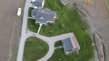 An aerial view of a residential area with multiple houses, roads, and a small parking area.