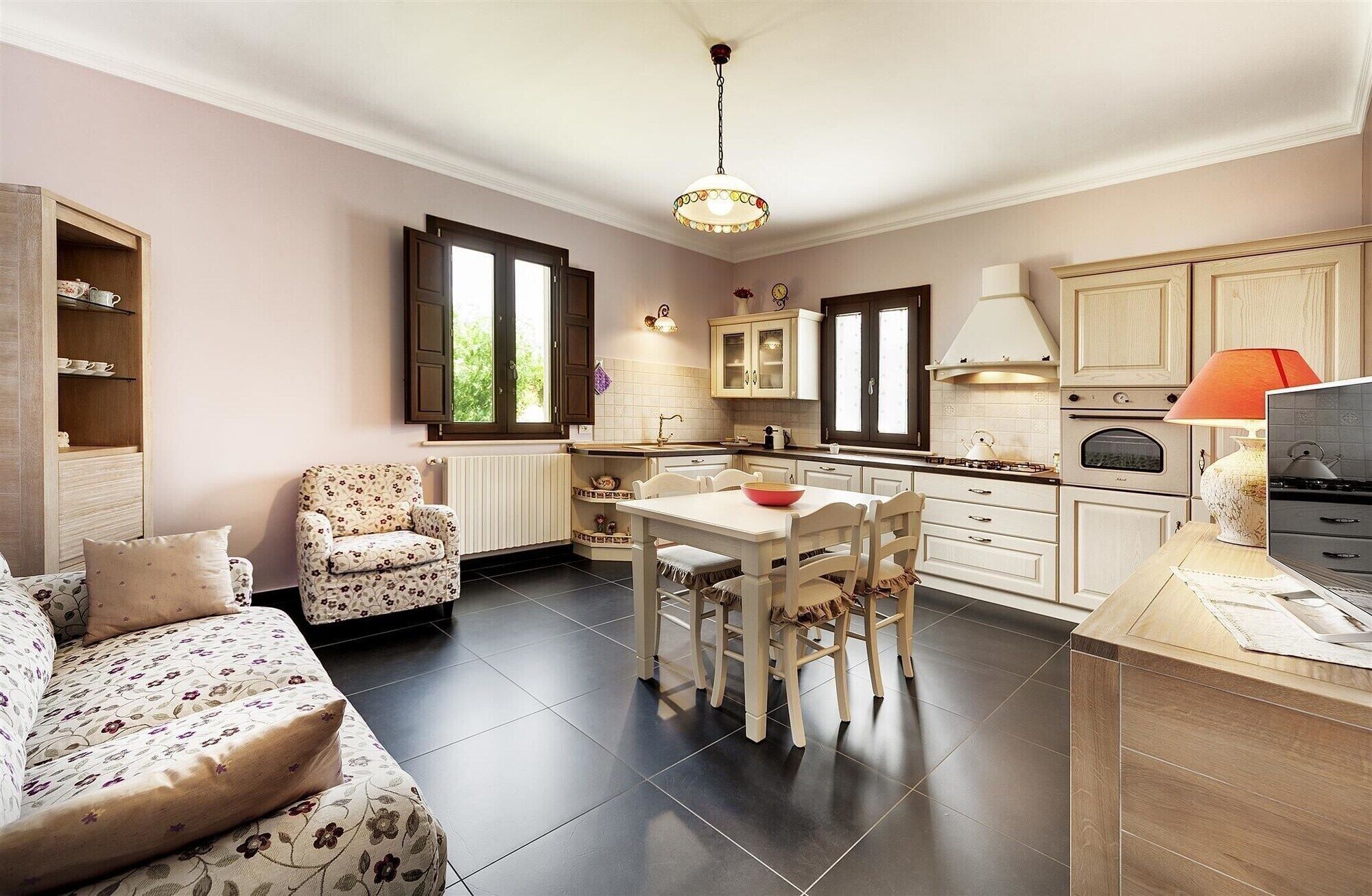 Una cocina acogedora con una mesa de comedor, sillas, un sofá y un televisor.