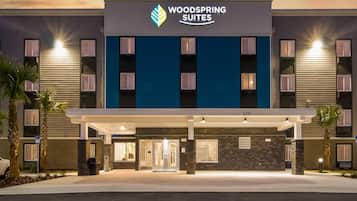 Un hotel con fachada moderna, un logotipo destacado y un número que indica su dirección.