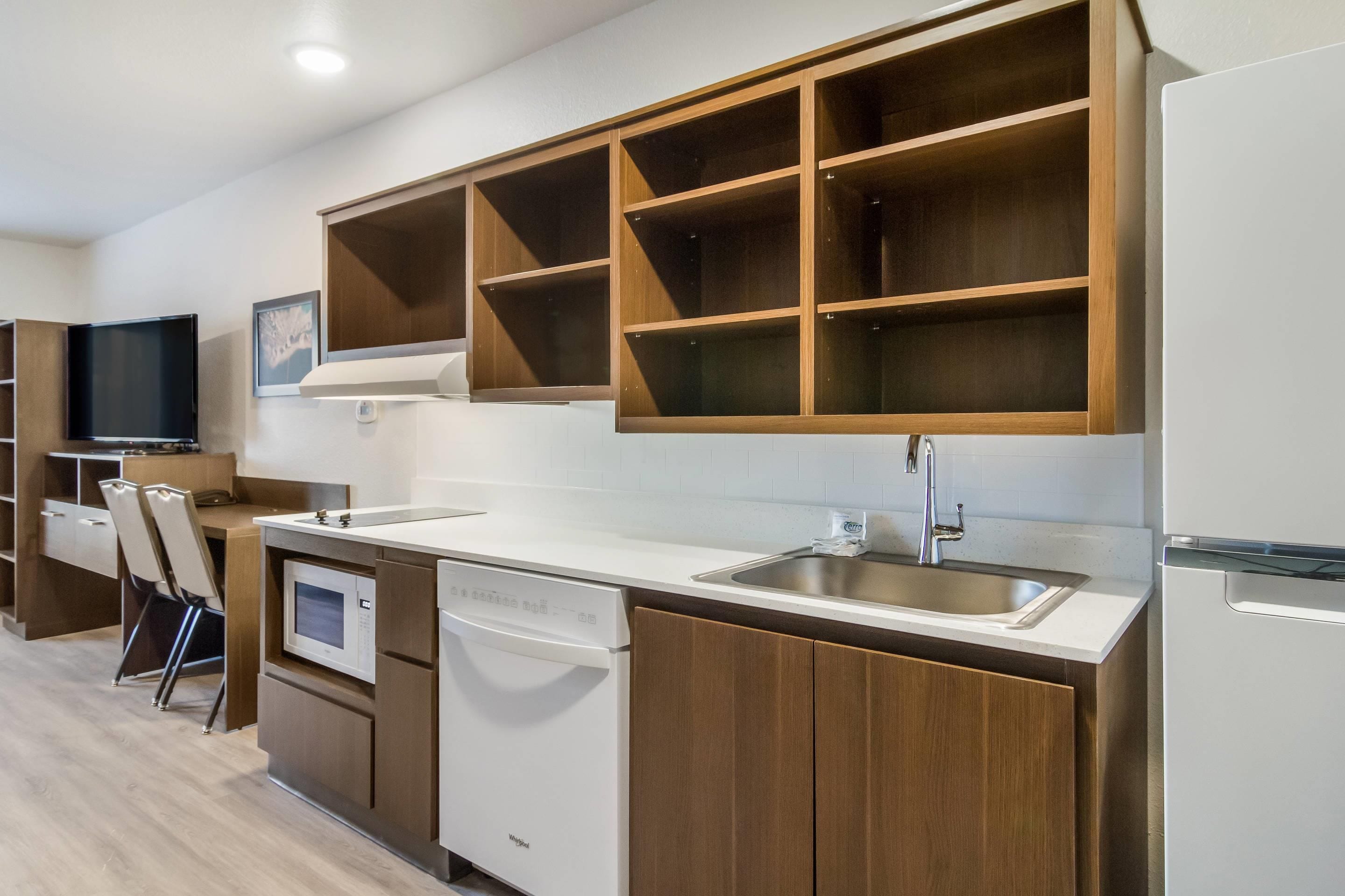 Een moderne keuken met inbouwmeubels, een vaatwasser en een spoelbak.