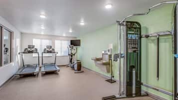 Un gimnasio con cintas de correr, elípticas y máquinas de pesas.