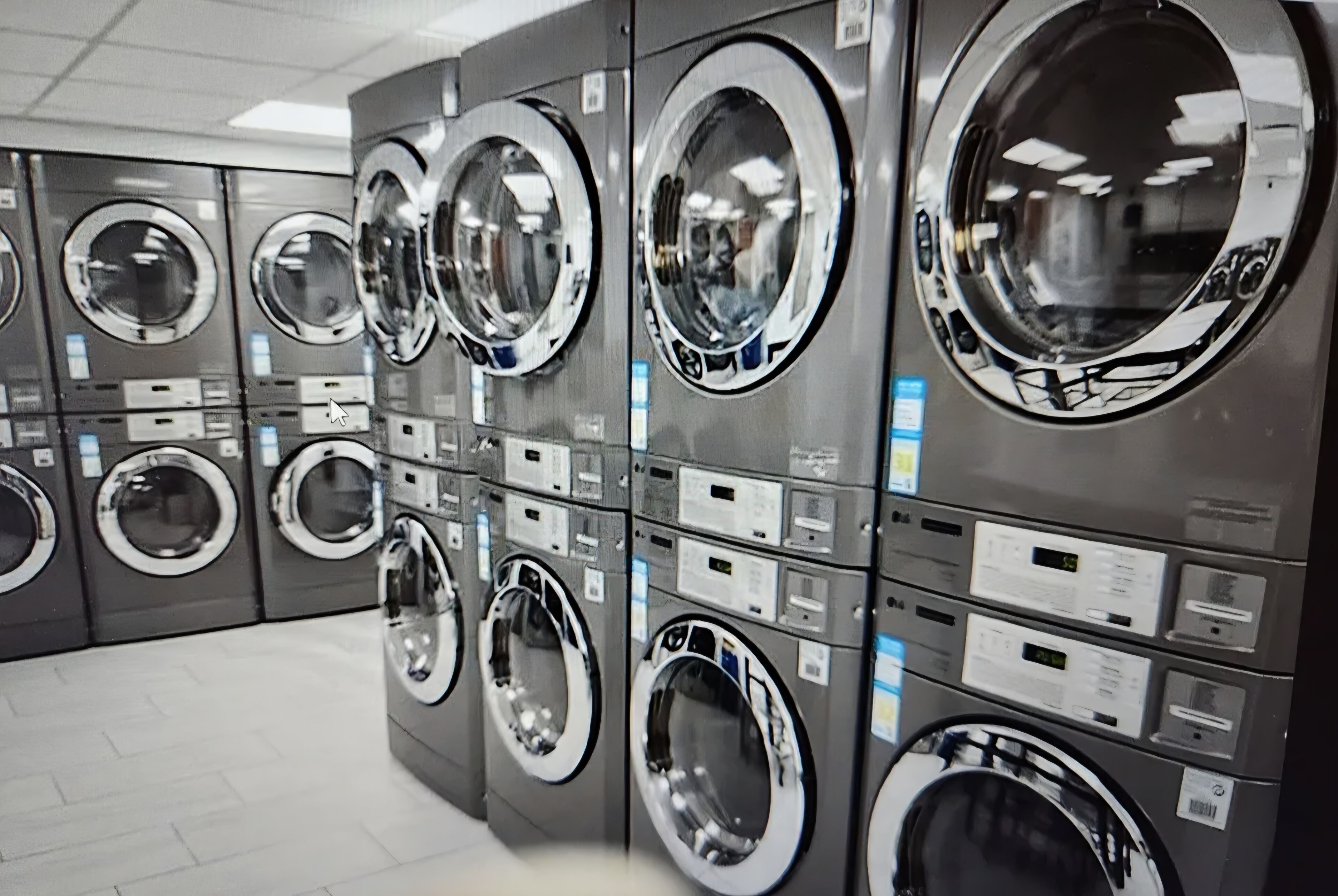 A row of industrial-style washing machines in a commercial setting.
