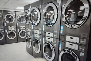 A row of industrial-style washing machines in a commercial setting.