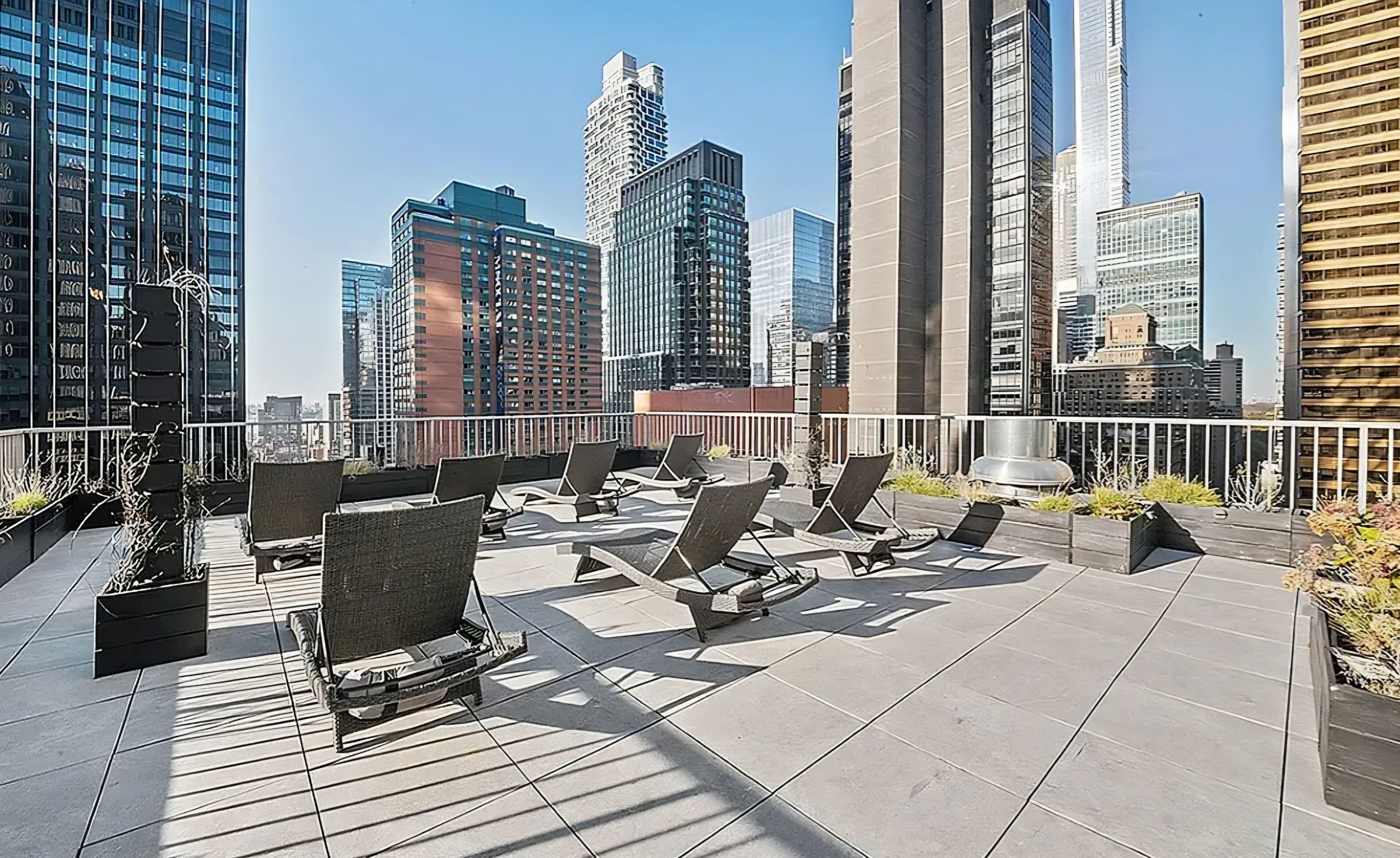 A rooftop terrace with outdoor seating and a city skyline view.