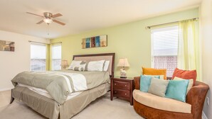A bedroom with a bed, a nightstand, a chair, and a ceiling fan. - Aviana Resort-ru1077 (Davenport)
