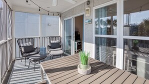 A balcony with a wooden table, two chairs, and a potted plant. - Gulf view, Pool, Deed Beach Beach Access in Santa Rosa Beach.  (Santa Rosa Beach)