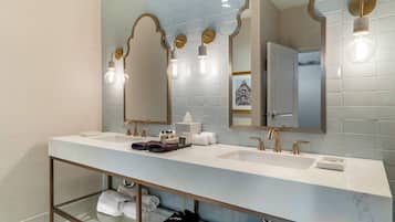 Une salle de bain moderne dotée d’un long meuble-lavabo, de deux vasques et d’une douche à l’italienne.