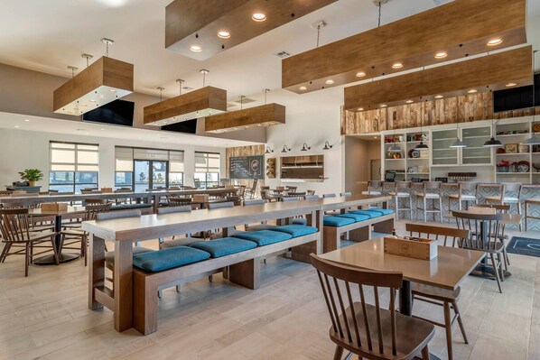 A spacious restaurant with high ceilings, wooden beams, and modern lighting fixtures. - Lyric Hotel West End, Trademark Collection by Wyndham (Cleveland)