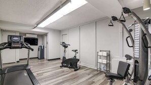 A gym with treadmills, an elliptical, and weight machines. - Econo Lodge Auburn I-95 (Auburn)